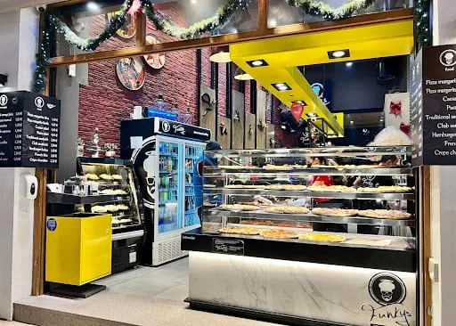 Ο πάγκος των Funky's με τη βιτρίνα των πιτσών κάτω από τους μαυροπίνακες του μενού.