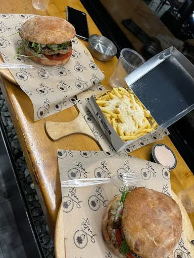 Δύο burger με τηγανητές πατάτες και παρμεζάνα, σε χαρτί Funky's.